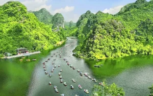 Traditional sampan boat tour navigating the river at Trang An Landscape Complex Ninh Binh