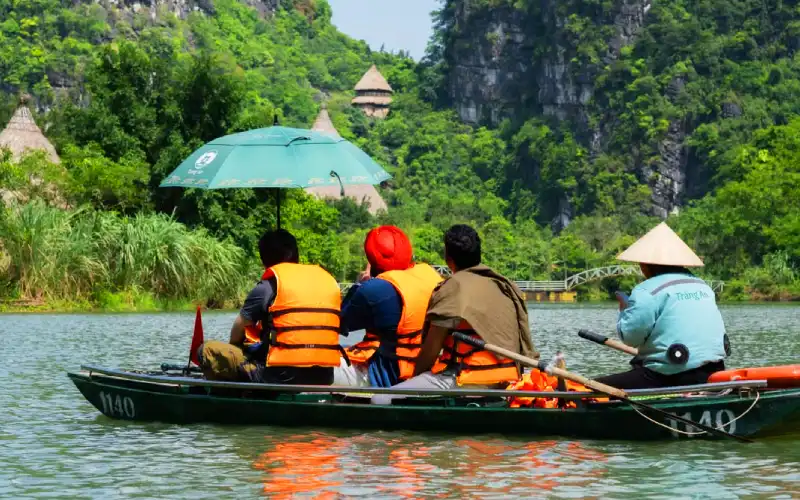 Traditional sampan boat tour navigating the river at Trang An Landscape Complex Ninh Binh